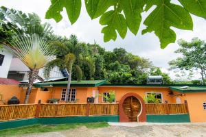 a house with a wooden fence and a palm tree at La Maison - Siquijor in Siquijor