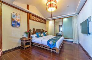 a bedroom with a large bed and a tv at Mengtianhu Inn in Lijiang