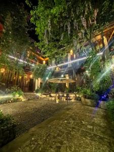 a building with a patio at night with lights at Mengtianhu Inn in Lijiang