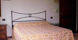 1 dormitorio con 1 cama con colcha de color naranja y amarillo en Le Fontane, en Urbino