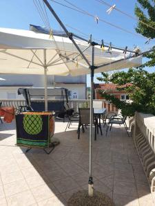 a patio with an umbrella and a table and chairs at Apartments in Pirovac 34905 in Pirovac
