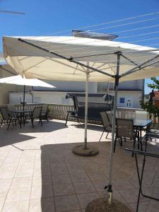 a table and chairs under an umbrella on a patio at Apartments in Pirovac 34905 in Pirovac