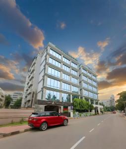 Un coche rojo aparcado delante de un edificio en HOTEL LAKE CASTLE - Parkview, en Dhaka