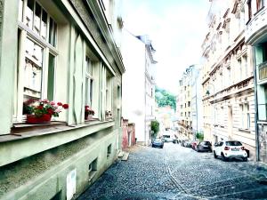 a street with buildings and a car parked on the street at Oasis Valley Karlovy Vary Center in Karlovy Vary