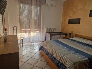 a bedroom with a bed and a table and a window at Elisa Adda House in Trezzo sullʼAdda +7 photos