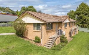 a small brick house with stairs in a yard at Walcha Villas in Walcha