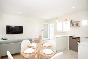 レッドクリフにあるAnchor at Redcliffe - Retreat on the Peninsulaの白いリビングルーム(テーブル、椅子付)