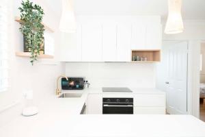 レッドクリフにあるAnchor at Redcliffe - Retreat on the Peninsulaの白いキッチン(白いキャビネット、シンク付) +5枚の写真