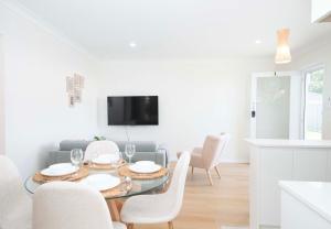 レッドクリフにあるAnchor at Redcliffe - Retreat on the Peninsulaの白いリビングルーム(テーブル、椅子付)