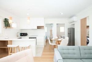 レッドクリフにあるAnchor at Redcliffe - Retreat on the Peninsulaの白いキッチン、リビングルーム(青いソファ付)