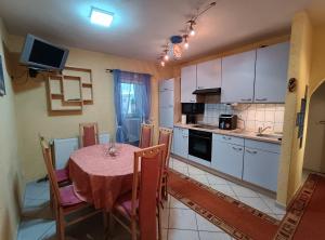 a kitchen with a table and a kitchen with white cabinets at Classic Apartment in Sibiu