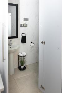 a white bathroom with a sink and a mirror at Relmies Place in Modimolle