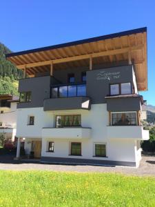 un grand bâtiment blanc avec un toit dans l'établissement Apart Höferauer Hof, à Kappl