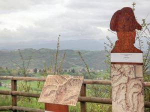 eine Statue einer Person mit einem Hut auf einem Zaun in der Unterkunft B&B I Colori dell'Arcobaleno in Belvedere Langhe