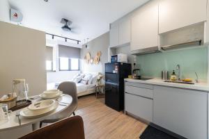 吉隆坡Riveria City KL Sentral by Sleepy Bear的厨房、带桌子的客厅、厨房以及客房。