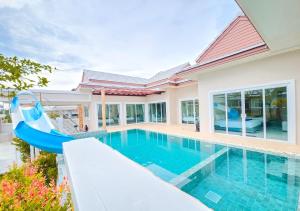 a swimming pool with a slide in a house at Khunnapat Pool Villa Pranburi in Ban Huai Thalaeng Phan