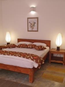 Un dormitorio con una cama con dos lámparas sobre dos mesas. en The Clouds Ahangama, en Ahangama