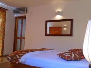 Un dormitorio con una cama y un espejo en la pared. en The Clouds Ahangama, en Ahangama