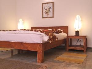 1 dormitorio con 1 cama de madera y 2 lámparas en The Clouds Ahangama, en Ahangama