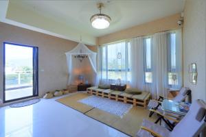 Una sala de estar con un sofá y algunas ventanas. en Najima B&B, en Jian