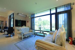 Una sala de estar con un sofá y una ventana grande. en Najima B&B, en Jian