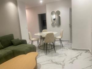 een woonkamer met een tafel, stoelen en een bank bij Chambre privée design, 8 min du Parc des Prince et de Roland Garros et à 4 min du métro 9 in Boulogne-Billancourt