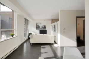 ビクトリアにあるChic & Modern Apartment In The Heart Of Downtownのリビングルーム(白いソファ、テレビ付)