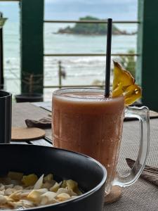 a drink in a glass mug next to a bowl of food at Arana Weligama in Weligama