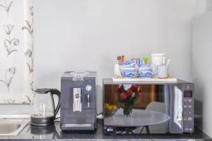 encimera de cocina con cafetera y microondas en 1-Bed Cottage ,Sleeps 3, Walk to Boys High and Bossa, en Paarl