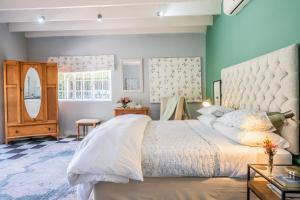 Un dormitorio con una cama grande y una pared azul. en 1-Bed Cottage ,Sleeps 3, Walk to Boys High and Bossa, en Paarl