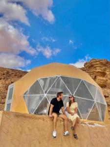 a man and a woman sitting in a tent at Wadi Rum in Al Jafr