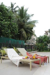 a patio with two lounge chairs and a table at The Hideout By NK in Assagao