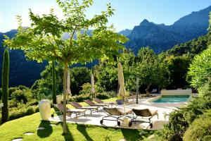 費里切托的住宿－卡斯安娜利迪婭- 魅力酒店，一组椅子和遮阳伞,位于游泳池旁