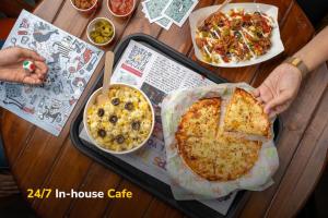 uma pessoa segurando uma pizza sobre uma mesa em goSTOPS Bir, Landing Site em Bir