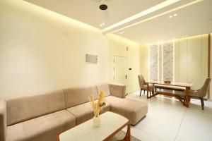 a living room with a couch and a table at Royale Suites - 3 BHK Serviced Apartment in Kadayirippu +26 photos