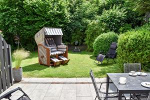 a backyard with a table and chairs and a gazebo at Ferienwohnung Gorch-Fock Scharbeutz in Scharbeutz