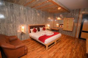 een slaapkamer met een bed en een stoel in een kamer bij Hotel Vivek in Coonoor +65 foto's