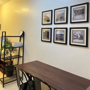 a dining room with a table and framed pictures on a wall at Cozy 2 Bedroom Home in Lucena with AC and Fast WiFi in Ilayang Dupay