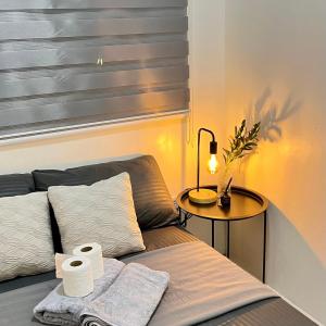 a bed with towels and a table with a lamp at Cozy 2 Bedroom Home in Lucena with AC and Fast WiFi in Ilayang Dupay +1 photo