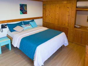 a bedroom with a large bed with blue and white sheets at RITRELLA FLOATING HOTEL&YACHT - FREE beach access daily - Full board meal plan in Male City