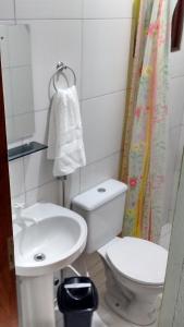 a small bathroom with a toilet and a sink at Pousada Paraiso dos Galos in Galinhos