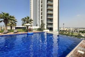 une grande piscine devant un grand immeuble dans l'établissement PVH - Modern 1BR with Golf Course View - Golf Gate, à Dubai Marina