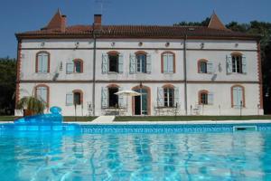 un grande edificio con piscina di fronte di Manoir des Chanterelles a Meauzac