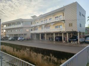 a large building with cars parked in a parking lot at Très Bel Appartement Moderne-1 Appartement Nuptial in Libreville