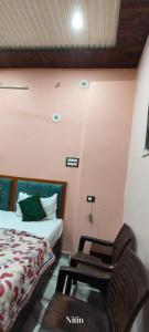 um quarto com uma cama e uma cadeira em Rudraksh Kashi inn guest house em Varanasi