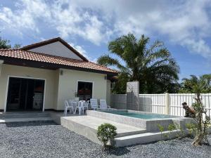a house with a swimming pool in front of it at Villa Mokara Brassia 2 bedrooms by orchids pool villas in Ko Lanta