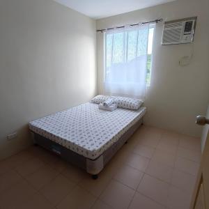 a bedroom with a bed in a room with a window at Rae Condo at Marina Spatial Seaview and Mountain View in Aganan +25 photos