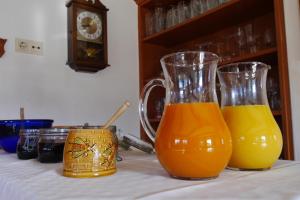 two glasses of orange juice sitting on a table at Pension Patz in Schladming