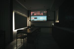 una habitación oscura con un televisor, una mesa y sillas en Nancheng Renlan, en Anping