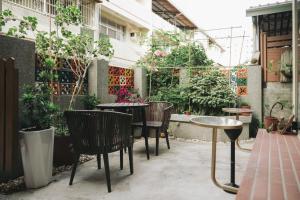 Un patio al aire libre con mesas, sillas y plantas. en Nancheng Renlan, en Anping